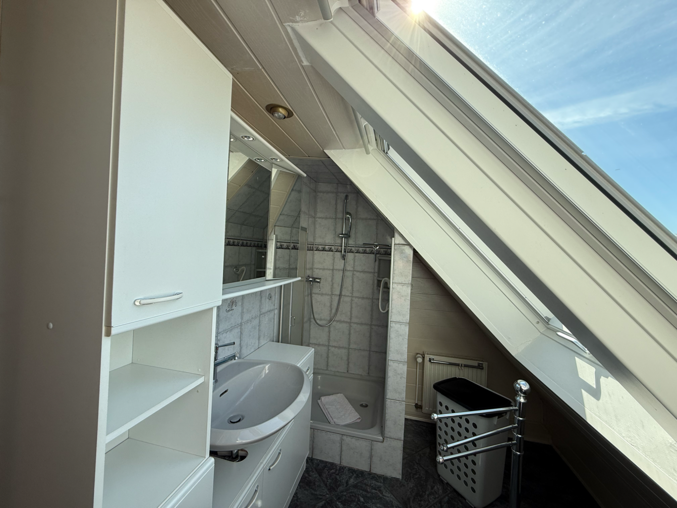 Bad ausgestattet mit Dusche, Waschtisch mit Spiegelschrank und WC